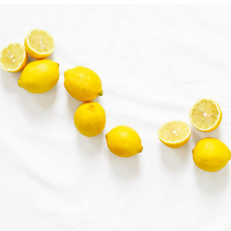 several lemons on a white background to be combined with white distilled vinegar.