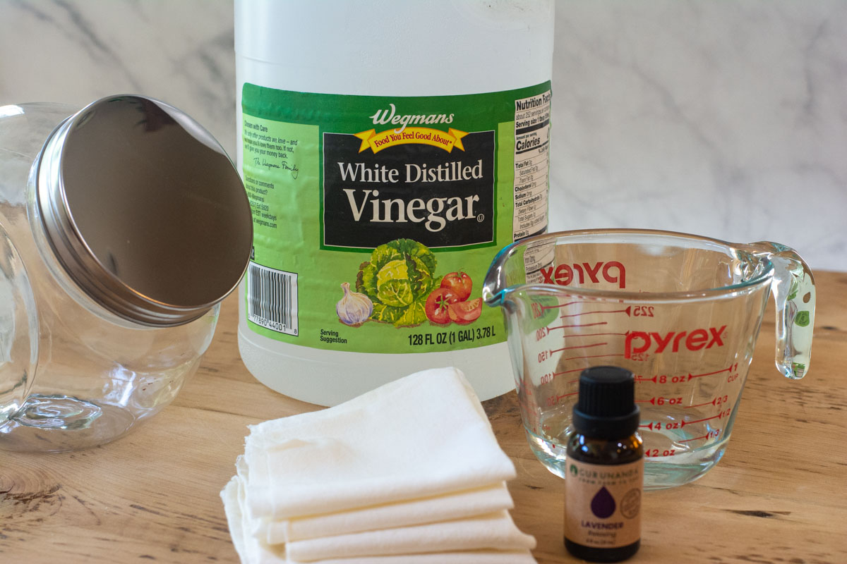 table with ingredients to make dryer sheets including vinegar and lavender essential oil